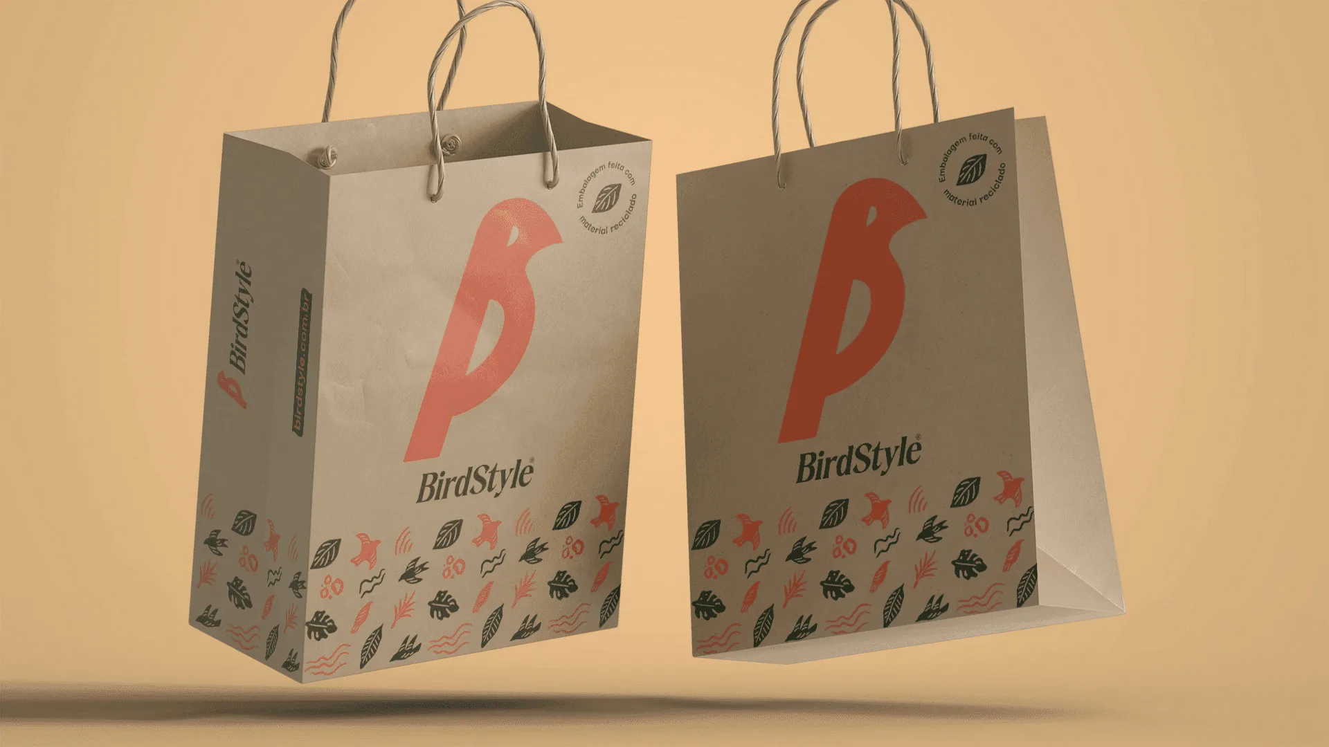 Duas sacolas de papel da BirdStyle com o símbolo do pássaro em laranja e faixa de grafismos naturais na base